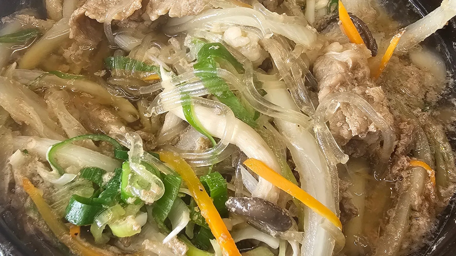 당면과 고기, 양파, 대파가 함께 끓는 뚝배기불고기
